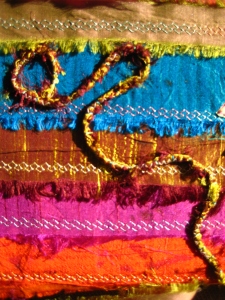 I made some cord using machine stitch over sari-ribbon and then couched it onto the cover